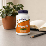 NOW Foods Betaine HCl 648 mg bottle with vegetarian capsules on a kitchen counter
