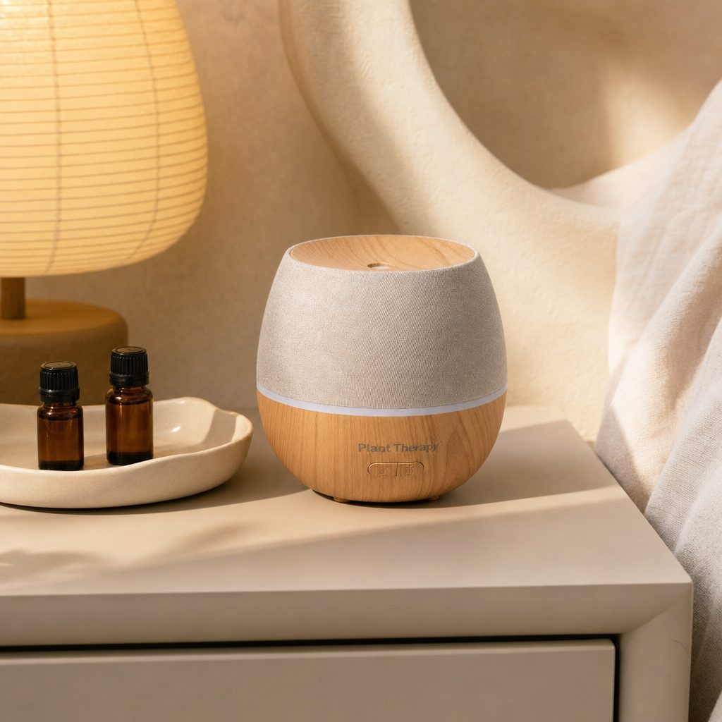 Plant Therapy Drift Linen Diffuser on a tabletop with soft mist and ambient light