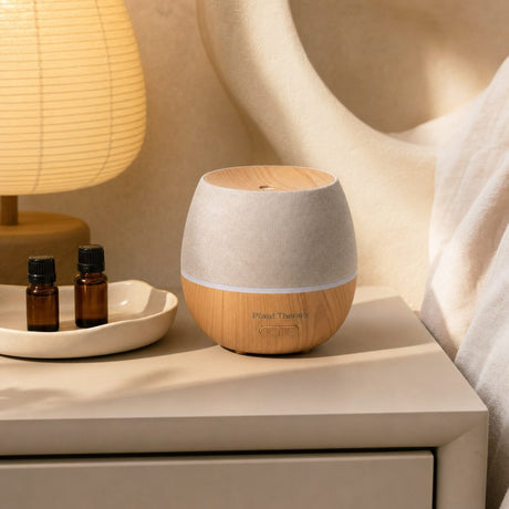 Plant Therapy Drift Linen Diffuser on a tabletop with soft mist and ambient light
