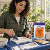 NOW Foods Empty Gelatin Capsules #1 pouch beside a woman filling capsules on a capsule-filling tray
