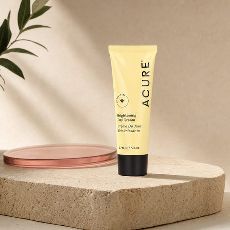Acure Brightening Day Cream 1.7 fl oz tube shown with brightening skincare graphics