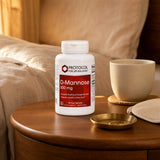 Protocol for Life Balance D-Mannose 500 mg bottle on a bathroom counter with a glass of water