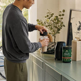 Ancient Nutrition Multi Protein Chocolate powder tub on a kitchen counter