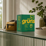 Woman holding Grüns Adult Superfood Greens Gummies Original Low Sugar daily pack