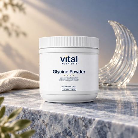Vital Nutrients Glycine Powder container on a marble ledge beside a glass crescent moon and a towel