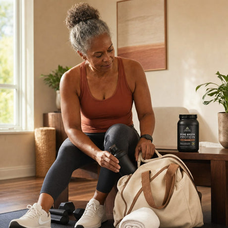 Woman enjoying Ancient Nutrition Bone Broth Protein Chocolate in a kitchen lifestyle scene
