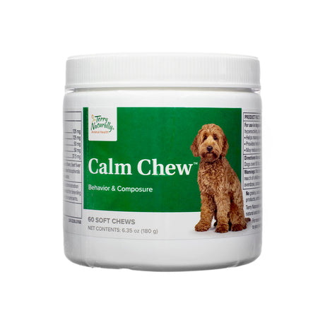 A white plastic jar of Terry Naturally Calm Chew, displaying the front label with product branding. The label highlights behavior and composure support for dogs, with a green background and an image of a brown dog. The product contains 60 soft chews, with a net weight of 6.35 oz (180g).