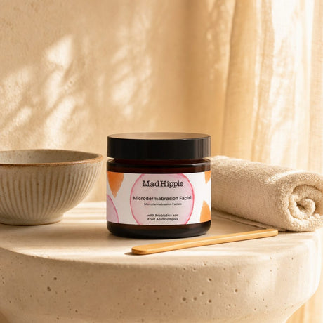 Mad Hippie MicroDermabrasion Facial open jar with cream scrub texture and pink flowers